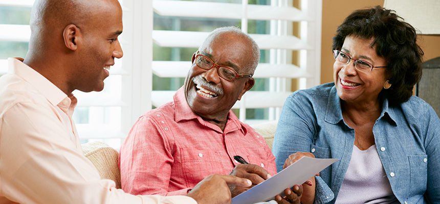older couple smiling and looking over a document