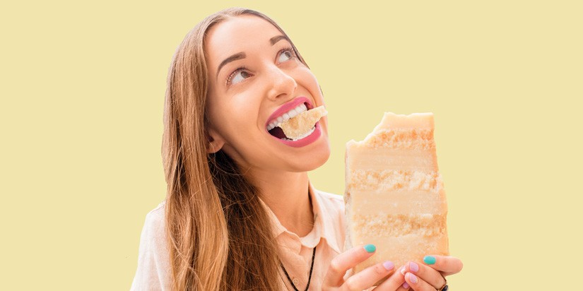 Person holding a large piece of cheese