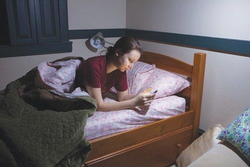 Student setting alarm before going to sleep