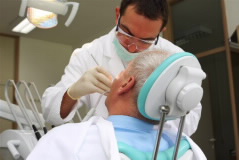 A dentist works on a patient's mouth