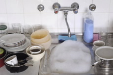 A sink filled with bubbles and dirty dishes