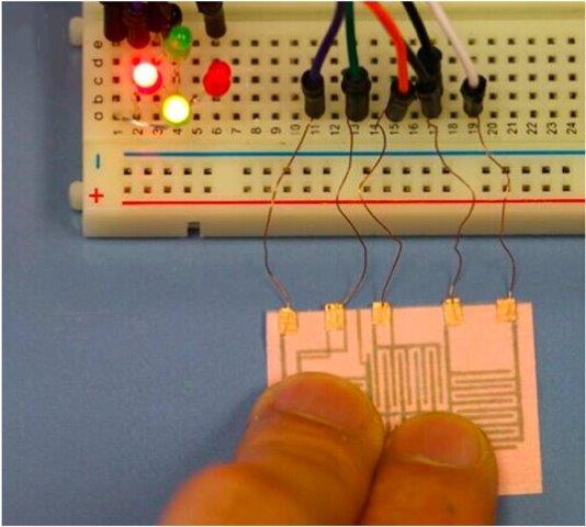 Paper-based, inexpensive electronics connected to an electronics bread board