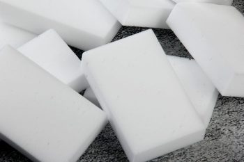 Several white, rectangular melamine cleaning sponges on a counter.